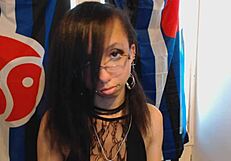 young goth girl in glasses slips on dark red lipstick teases huge puffy nipples