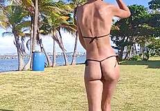 brunette flashes hairy pussy and small tits stripping thong on public beach