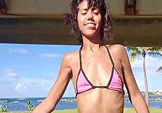 brunette flashes hairy pussy and small tits stripping thong on public beach