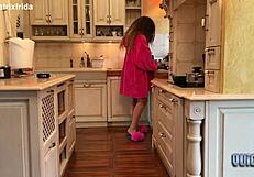 kicking off furry slippers to tease bare feet in kitchen