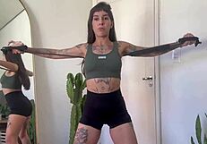 Inked babe stretches with rubber bands in sfw yoga fitness warm-up