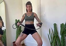 Inked babe stretches with rubber bands in sfw yoga fitness warm-up