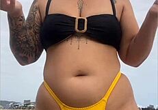 young african usa girl in tight yellow bikini splits swollen pussy on beach