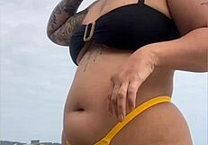 young african usa girl in tight yellow bikini splits swollen pussy on beach