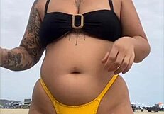 young african usa girl in tight yellow bikini splits swollen pussy on beach