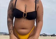 young african usa girl in tight yellow bikini splits swollen pussy on beach