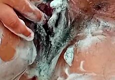check out this young brunette shaving her hairy pussy up close in the bathroom mirror