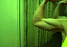 Muscular bodybuilder babe flexes bulging biceps in tight bikini for worship
