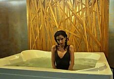 Petite brunette teases in jacuzzi