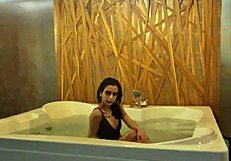 Petite brunette teases in jacuzzi